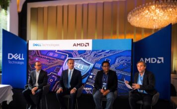 Innovación y ciberresiliencia en el nuevo ecosistema digital junto a Dell Technologies, AMD y CISO Club Fotografía en plano general de cuatro panelistas sentados en un escenario frente a una gran pantalla azul de Dell Technologies y AMD, participando en un panel ante mesas de invitados.