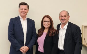 Xerox impulsa el mercado gráfico en México con nueva tecnología digital y automatización Fotografía en plano medio de tres ejecutivos de Xerox: Hubert Soviche con saco azul marino a la izquierda, Silvia Gómez al centro con saco negro y blusa lila, y Alejandro Jalife a la derecha de traje oscuro y camisa blanca, sonriendo frente a una pared beige neutra.