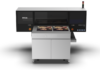 Epson y Alpha Beta impulsan la impresión profesional en Expo Photo Master Class 2026 Fotografía en render de producto con vista frontal de la impresora UV de cama plana Epson SureColor V4000 de color gris y negro sobre un fondo blanco aislado, mostrando impresiones de retratos fotográficos en su cama de trabajo.
