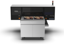 Epson y Alpha Beta impulsan la impresión profesional en Expo Photo Master Class 2026 Fotografía en render de producto con vista frontal de la impresora UV de cama plana Epson SureColor V4000 de color gris y negro sobre un fondo blanco aislado, mostrando impresiones de retratos fotográficos en su cama de trabajo.