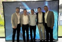 Innovación y expansión para el futuro en TD SYNNEX Power Up 2026 Fotografía de grupo de los cinco directivos principales de TD SYNNEX México —Jaime Venegas, Gerardo Calderón, Raffaelo Piccolo, Fabián Gómez y José Luis Chávez— posando abrazados y sonrientes frente a una mampara publicitaria azul de Power Up México 2026.
