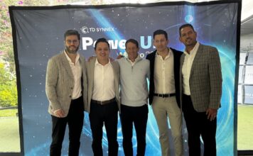 Innovación y expansión para el futuro en TD SYNNEX Power Up 2026 Fotografía de grupo de los cinco directivos principales de TD SYNNEX México —Jaime Venegas, Gerardo Calderón, Raffaelo Piccolo, Fabián Gómez y José Luis Chávez— posando abrazados y sonrientes frente a una mampara publicitaria azul de Power Up México 2026.