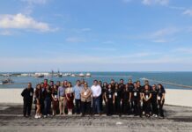 Grupo CVA fortalece al canal de tecnología en Veracruz con la asistencia de más de 120 distribuidores Fotografía grupal en plano entero del equipo organizador de Grupo CVA posando sonrientes en una terraza ejecutiva con el puerto y el mar de Veracruz al fondo.