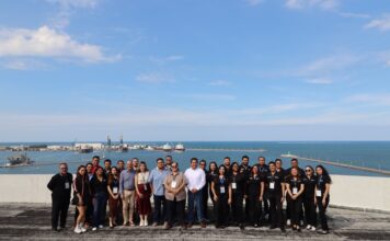 Grupo CVA fortalece al canal de tecnología en Veracruz con la asistencia de más de 120 distribuidores Fotografía grupal en plano entero del equipo organizador de Grupo CVA posando sonrientes en una terraza ejecutiva con el puerto y el mar de Veracruz al fondo.