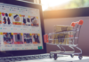 Estudio de Hostinger: el 51 % de las tiendas online sin preparación previa sufrió fuertes caídas en El Buen Fin Carrito de compras miniatura con detalles rojos que transporta dos paquetes de cartón sobre el teclado de una computadora portátil abierta, mostrando en la pantalla desenfocada un catálogo de comercio electrónico con productos y descuentos.