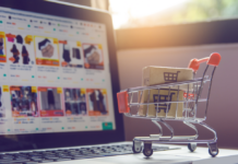 Estudio de Hostinger: el 51 % de las tiendas online sin preparación previa sufrió fuertes caídas en El Buen Fin Carrito de compras miniatura con detalles rojos que transporta dos paquetes de cartón sobre el teclado de una computadora portátil abierta, mostrando en la pantalla desenfocada un catálogo de comercio electrónico con productos y descuentos.