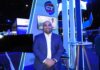 CT Internacional y su visión de liderazgo para transformar el canal TI Fotografía en plano medio de Juan Pablo Rojo, Director Adjunto de Marcas en CT Internacional, luciendo un saco azul marino sobre camisa blanca, posando sonriente con las manos entrecruzadas frente al estand con iluminación azul y pantalla interactiva del mayorista.
