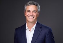 Lenovo nombra a Diego Majdalani como nuevo Presidente para América Latina Fotografía de retrato corporativo en plano medio de Diego Majdalani, Vicepresidente Sénior de Lenovo y Presidente para América Latina, vistiendo saco azul marino sobre camisa blanca de vestir sin corbata, sonriendo frente a un fondo gris neutro.
