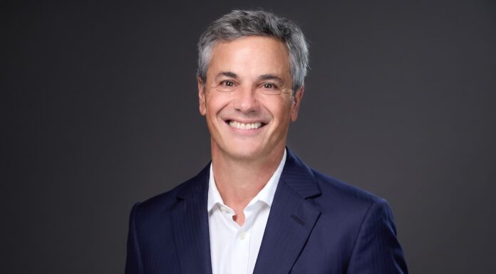 Lenovo nombra a Diego Majdalani como nuevo Presidente para América Latina Fotografía de retrato corporativo en plano medio de Diego Majdalani, Vicepresidente Sénior de Lenovo y Presidente para América Latina, vistiendo saco azul marino sobre camisa blanca de vestir sin corbata, sonriendo frente a un fondo gris neutro.
