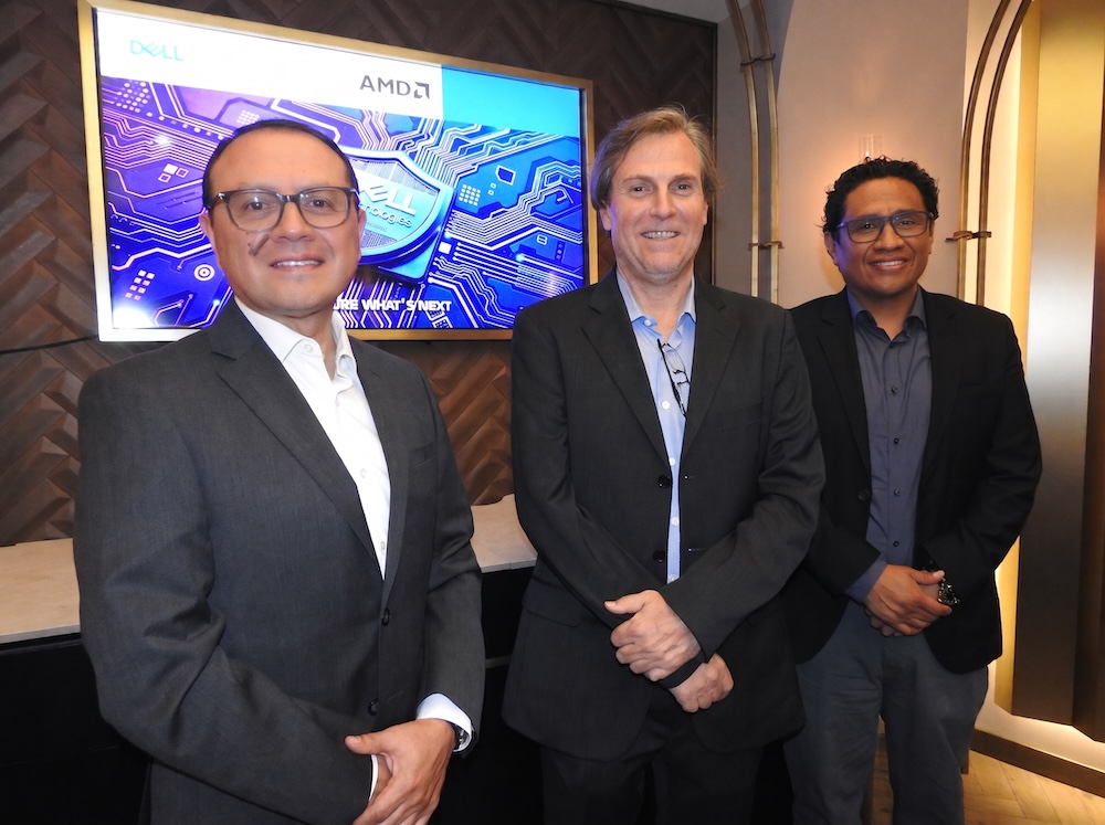 Fotografía en plano medio de tres ejecutivos de tecnología —Hiram Monroy de AMD, Christian Abate de Dell Technologies y Víctor García de Sophos— posando sonrientes de pie frente a una pantalla corporativa con los logotipos de Dell y AMD.