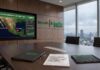Resiliencia ante el clima extremo: Schneider Electric destaca el valor de la visibilidad energética en emergencias Fotografía de una sala de juntas ejecutiva de Schneider Electric con vista a una ciudad lluviosa, mostrando una pantalla con un mapa de México que monitorea en tiempo real los huracanes Polo y Rachel junto a métricas de infraestructura, y sobre la mesa de madera una carpeta, un informe de evaluación energética fechado en octubre de 2026 y una tableta digital.