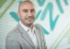 Veeam: La incómoda lección de octubre; sin resiliencia, la seguridad cibernética no es suficiente Fotografía de retrato corporativo en primer plano de Tomas Dacoba, sonriendo en saco gris claro sobre un fondo con patrones gráficos en tonos verde y blanco.