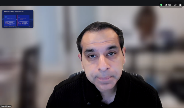 Captura en primer plano de Varun Chhabra, Vicepresidente Senior de Marketing de Producto en el Grupo de Soluciones de Infraestructura de Dell Technologies, durante una presentación virtual con la diapositiva en miniatura sobre la demanda de IA.