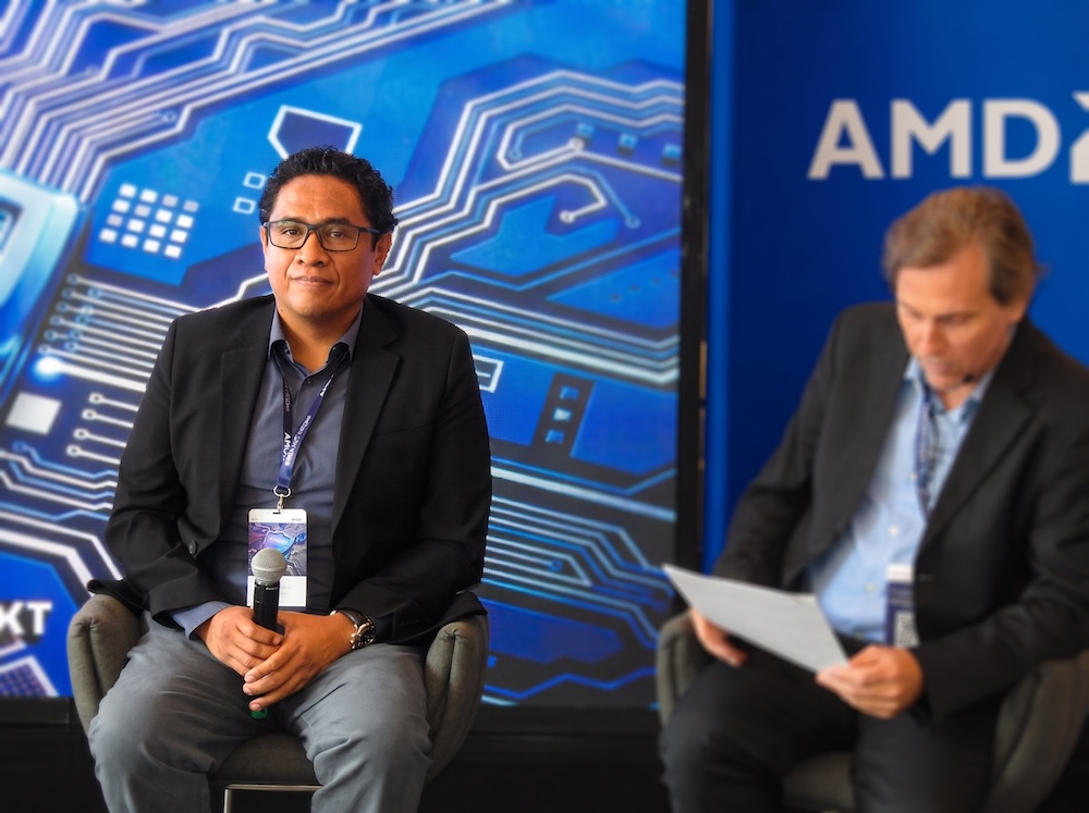 Fotografía en plano medio de Víctor García, Sr. Global Solutions Engineer en Sophos, sosteniendo un micrófono mientras escucha la intervención de Christian Abate de Dell Technologies a su lado.