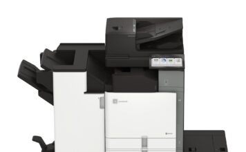 Xerox fortalece su oferta empresarial en México con la integración del portafolio A3 de Lexmark Fotografía en render de producto de vista frontal de la impresora multifuncional de gran formato Xerox Lexmark Serie 9 CX961 de color blanco y gris, equipada con alimentador automático de documentos, pantalla táctil interactiva, bandejas de papel de alta capacidad y un módulo de acabado lateral sobre fondo blanco aislado.