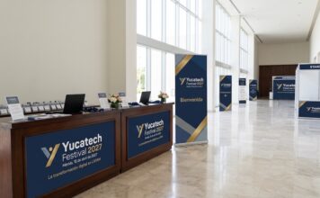 Yucatech Festival 2027: Mérida se consolida como el epicentro de la innovación tecnológica y los negocios en LATAM Fotografía en plano general del vestíbulo del Centro Internacional de Congresos de Yucatán con mostradores de registro, acreditaciones de prensa, mamparas informativas y banners publicitarios en azul y dorado del Yucatech Festival 2027.